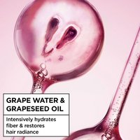Cut grape and liquid splash illustrating grape water and grapeseed oil